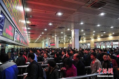 资料图：12月25日，2014春运临客车票在广州火车站开售，购票市民在售票窗口前排起长队。中新社发 陈骥旻 摄